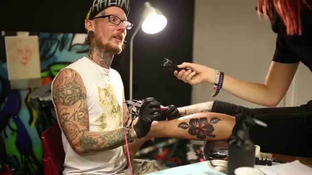 Artist researching tattoo conventions on a laptop