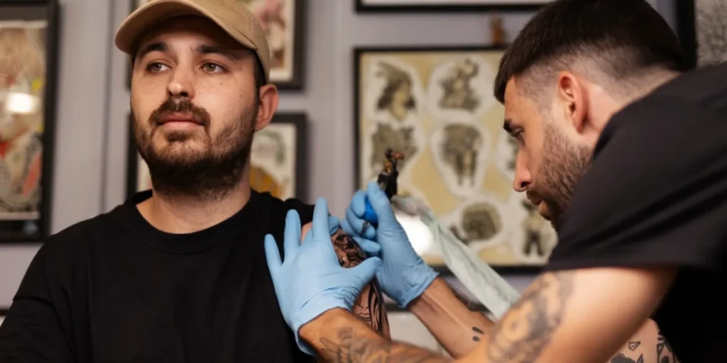 An open portfolio book displaying watercolor tattoo designs.
