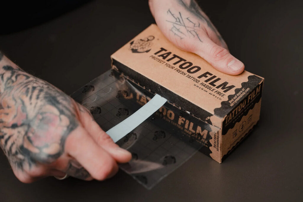 Transparent aftercare film covering a fresh fine line tattoo