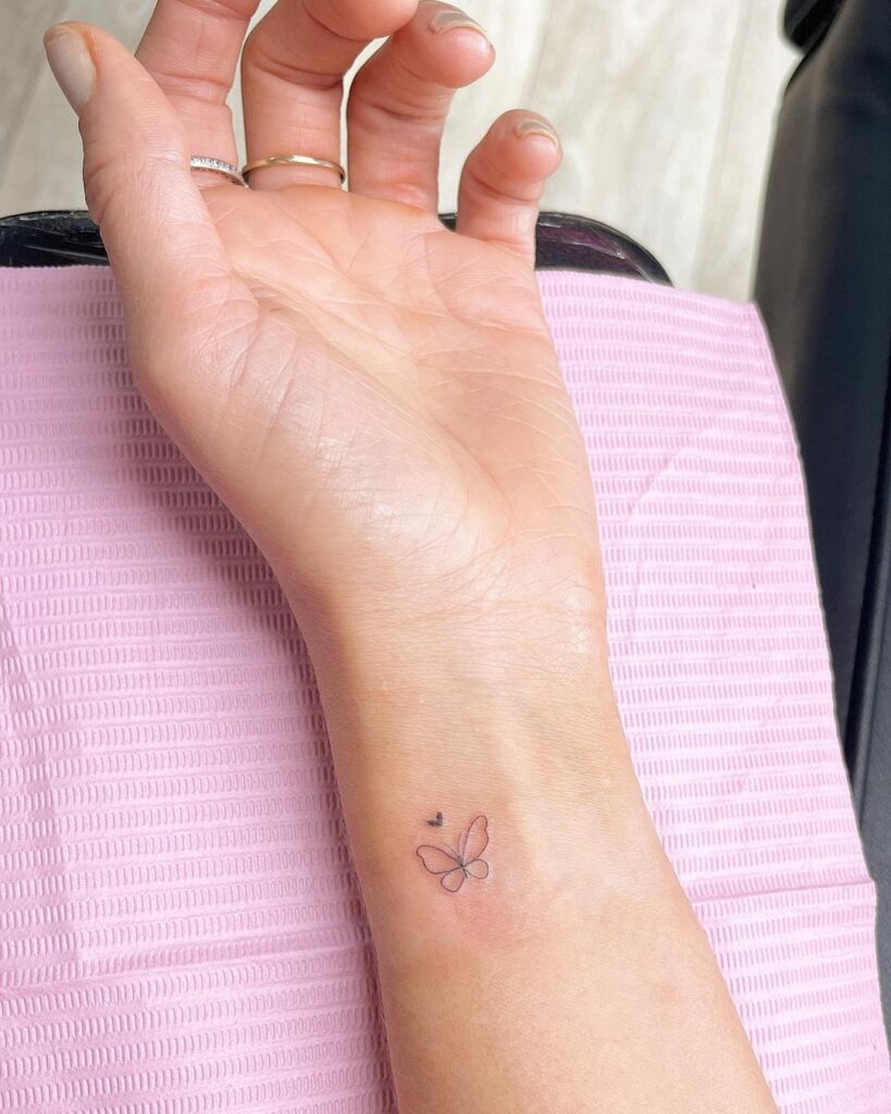 A healed fine line tattoo on the wrist showing minimal spread after one year