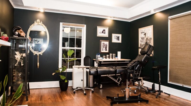 Tattoo artist concentrating while applying a fine line design on a client's arm.