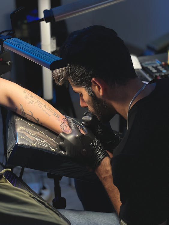Close-up of a tattoo machine with needle and ink caps on a clean table