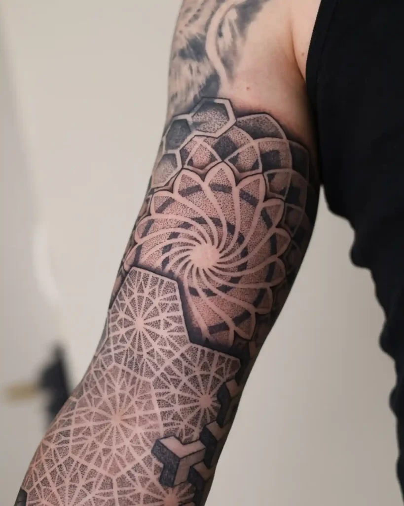 A tattoo consultation desk with geometric design sketches and ink caps.