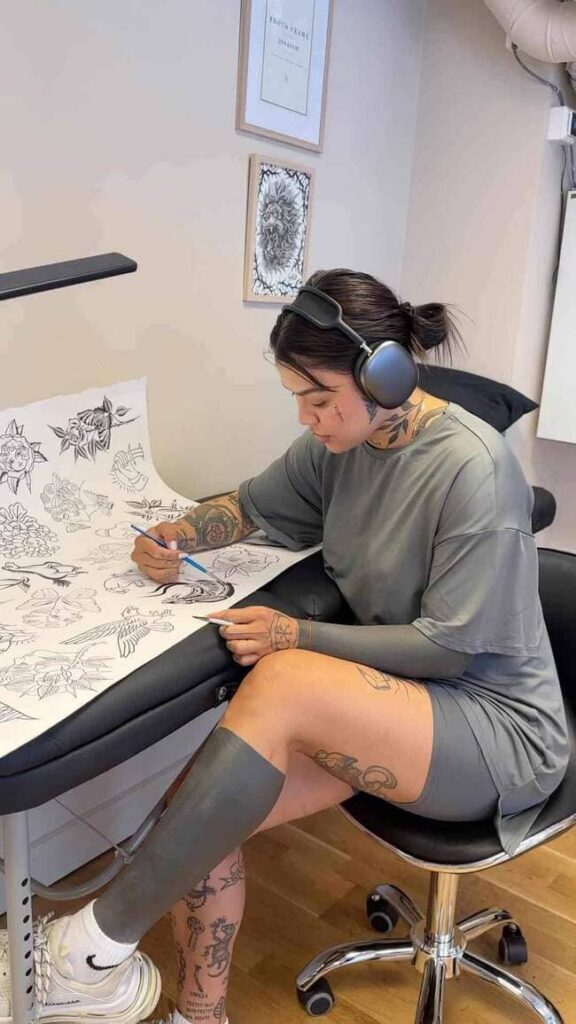 Tattoo artist sketching a minimal tattoo design on paper