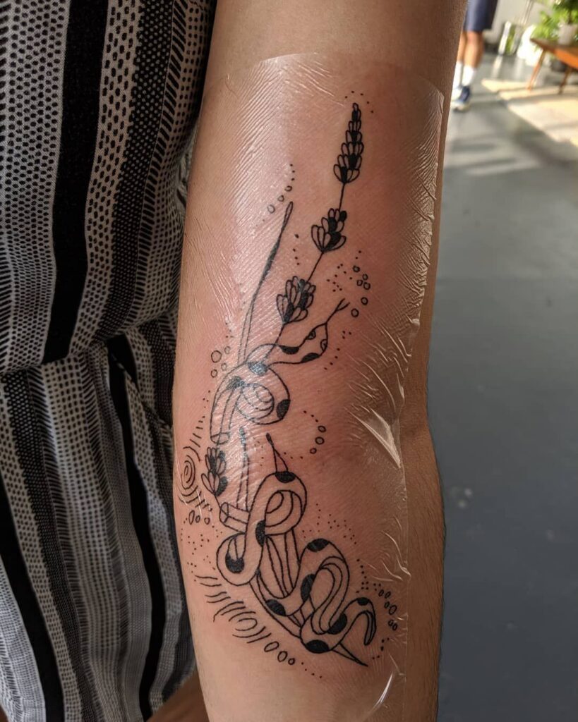A fresh cover-up tattoo wrapped in transparent aftercare film for healing
