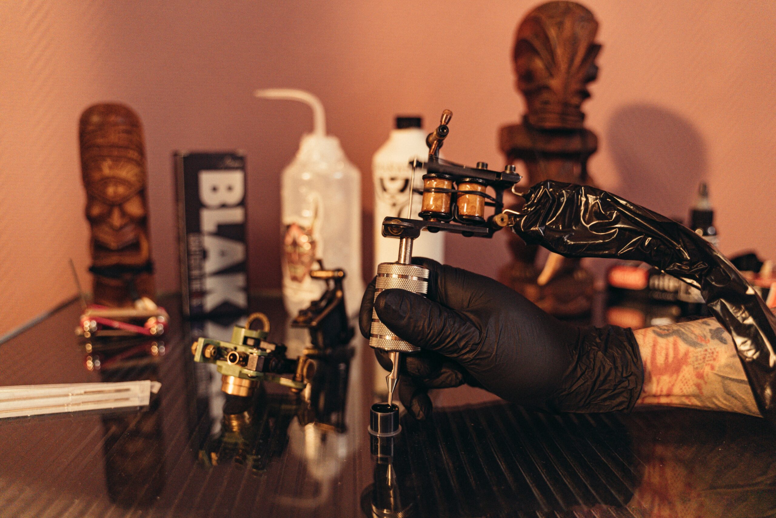 Close-up of a tattoo machine with needle and ink caps ready for use.