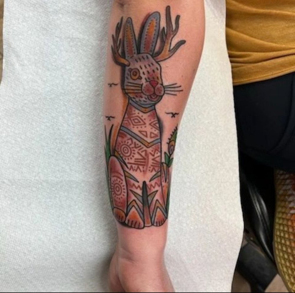 Artist placing stencil over scarred skin