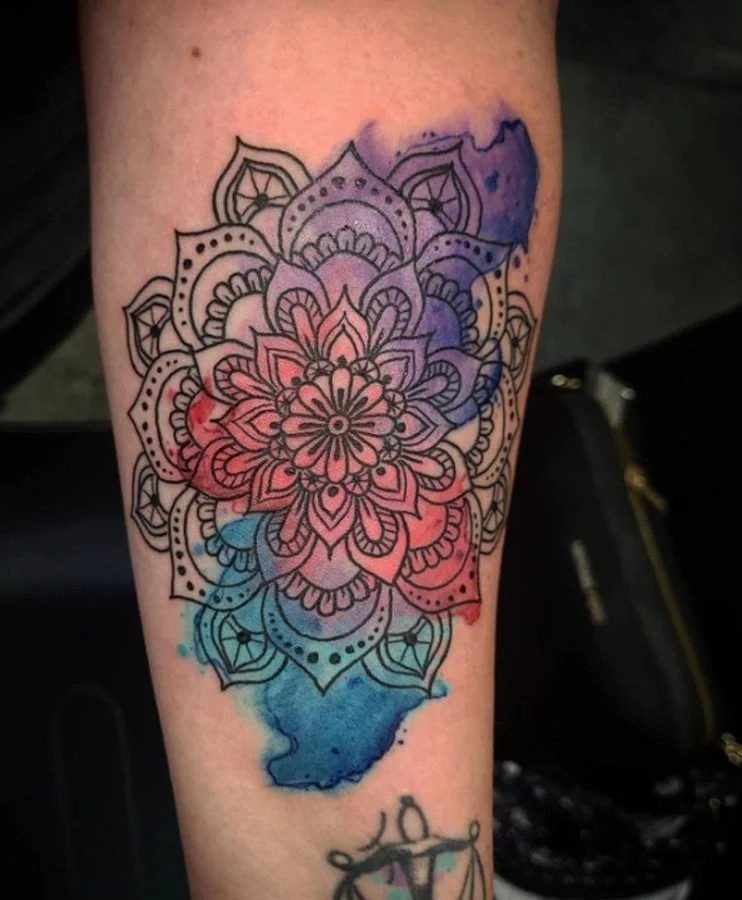 Watercolor tattoo with a soft, desaturated outline defining key shapes.