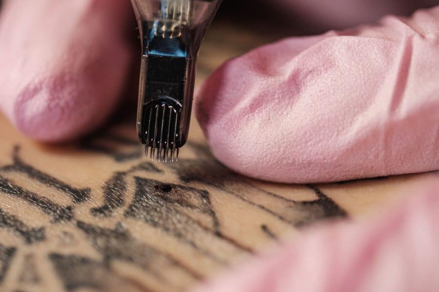 Stencil being applied to a forearm for a graphic tattoo design.