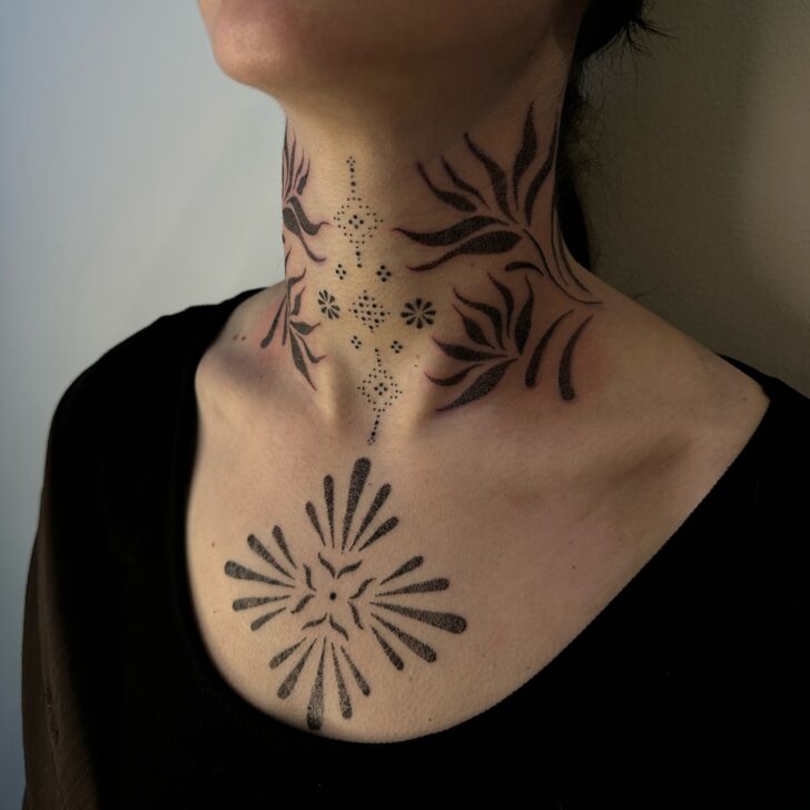 Close-up of an ornamental tattoo on the forearm showing radial symmetry with detailed geometric patterns.