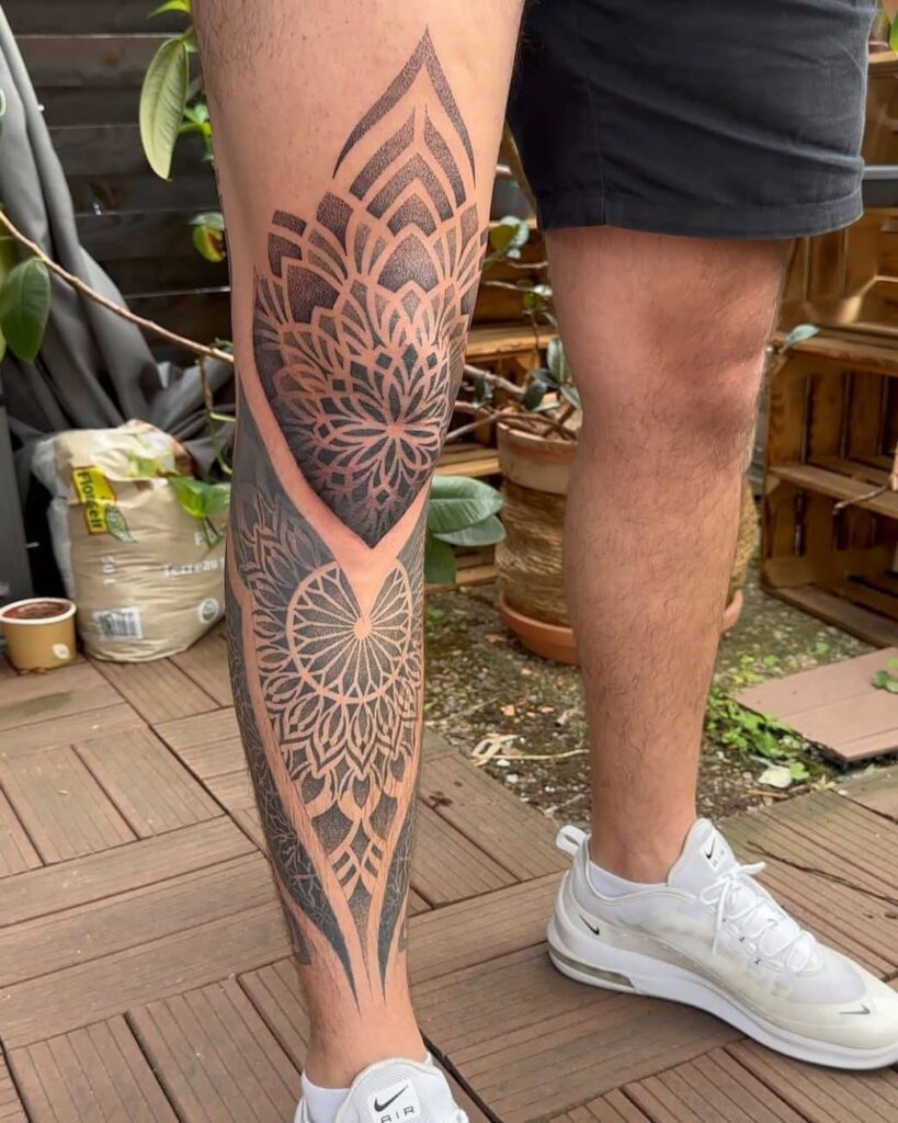 Geometric blackwork tattoo with wide negative space triangles for optical illusion.