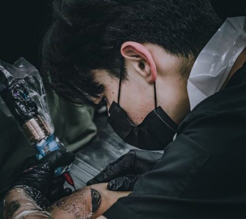 Nghệ sĩ xăm chuẩn bị bàn làm việc vô trùng trước khi bắt đầu buổi xăm fine line.