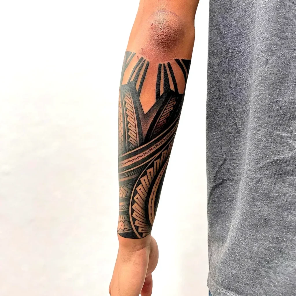 Hình xăm bộ lạc blackwork trên vai với mảng đen đặc và khoảng trống.