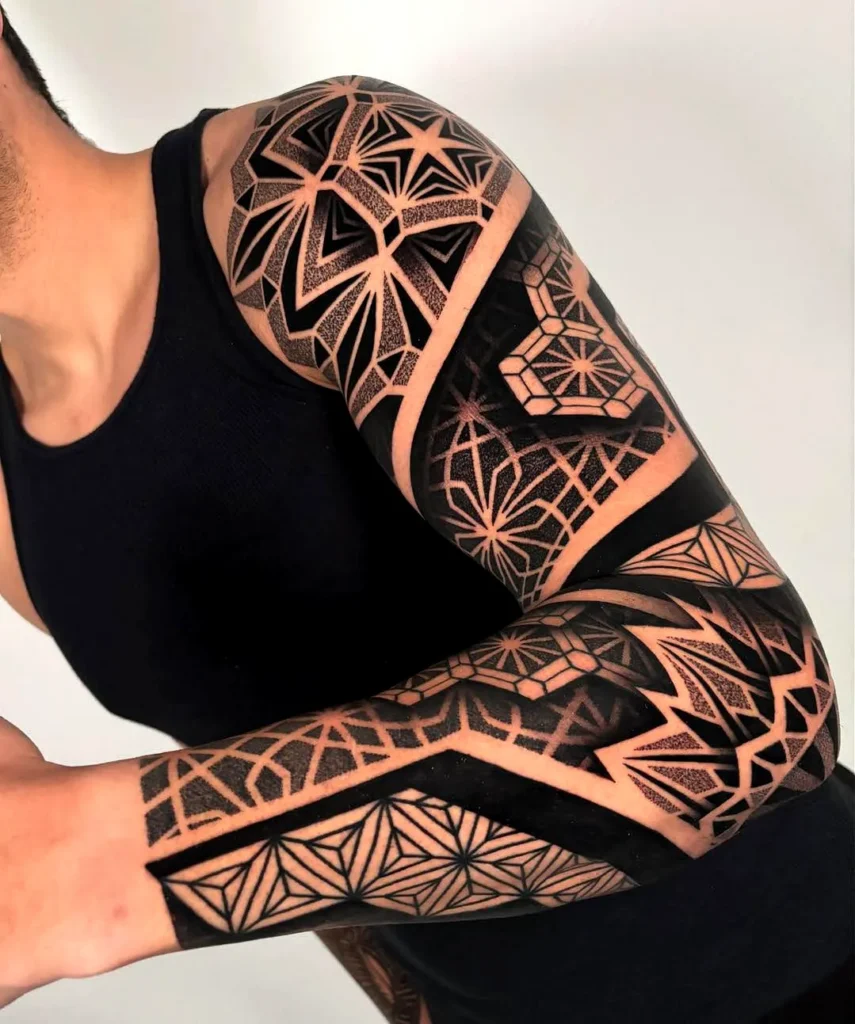 A black ink tattoo using negative space to form geometric shapes within a solid silhouette.