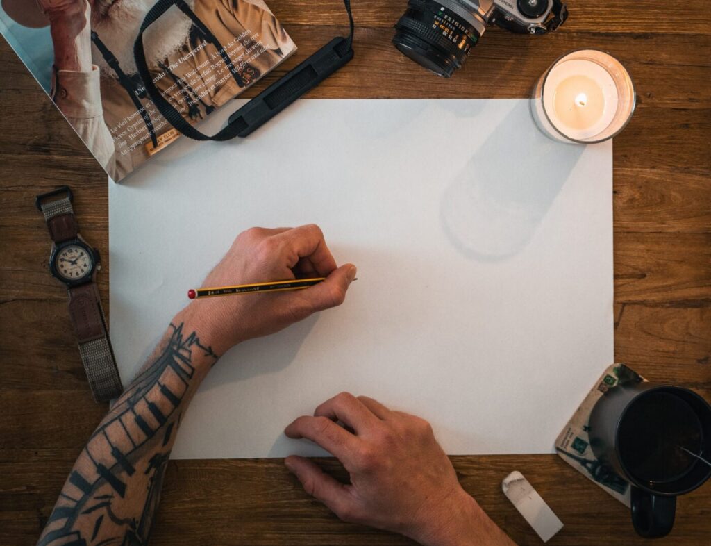 A tattoo artist carefully applying a stencil to the client's arm before tattooing.