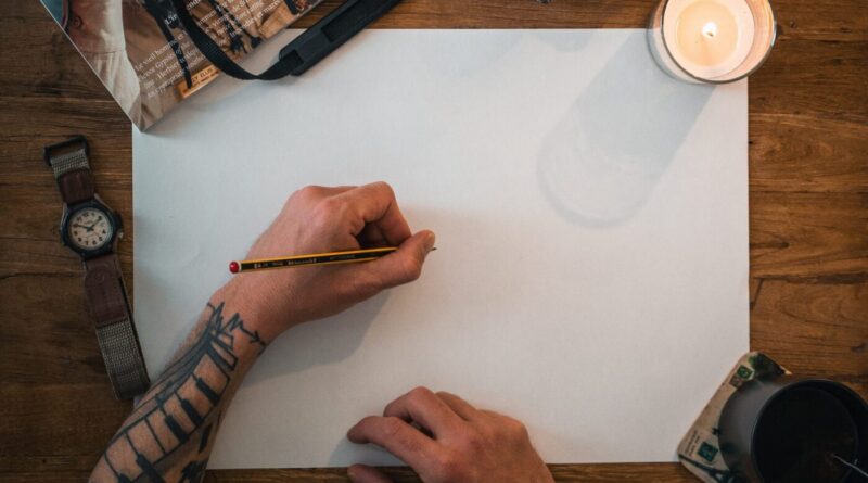 A tattoo artist carefully applying a stencil to the client's arm before tattooing.
