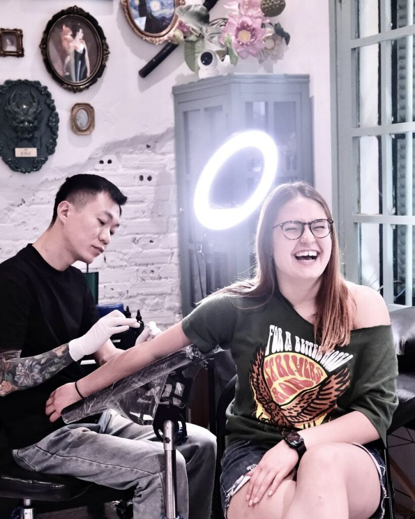 Thợ xăm làm việc với khách trong một buổi xăm tại studio chuyên nghiệp