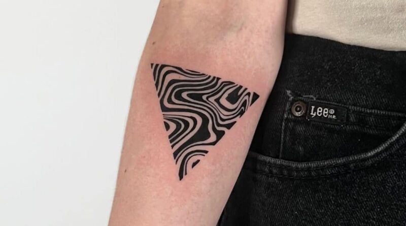 Tattoo artist carefully adjusting a stencil to ensure perfect alignment on the arm.