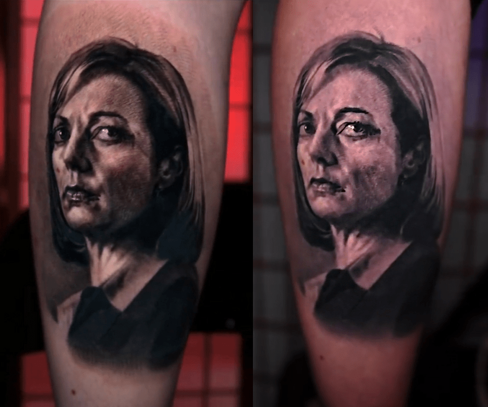 An aged black and grey tattoo showing loss of contrast over time.
