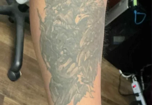 A faded black tattoo on an arm, ready for cover-up design