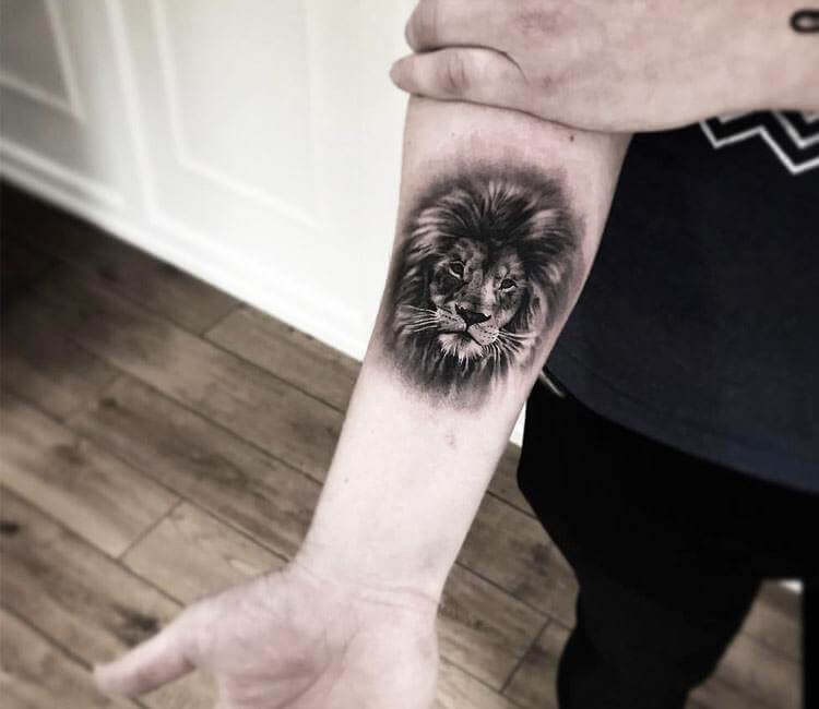 Tattoo artist placing a stencil on a client's arm with a ruler for scale