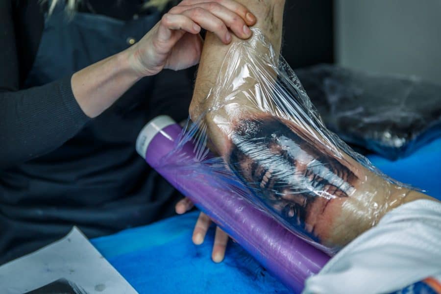 A fresh tattoo covered with a transparent aftercare film to protect it.