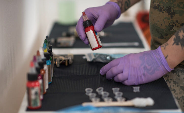 Tattoo artist arranging disposable ink caps on a sterile tray before a session.