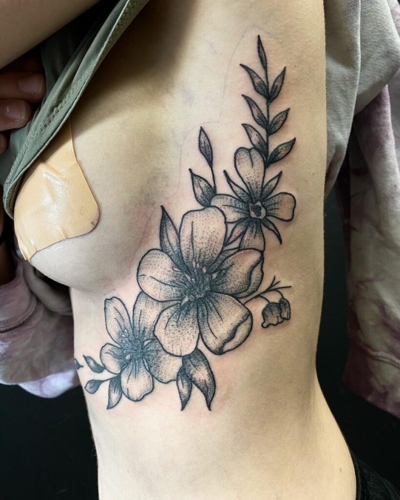 A tattoo being applied on the ribcage, a challenging area due to thin skin and movement.