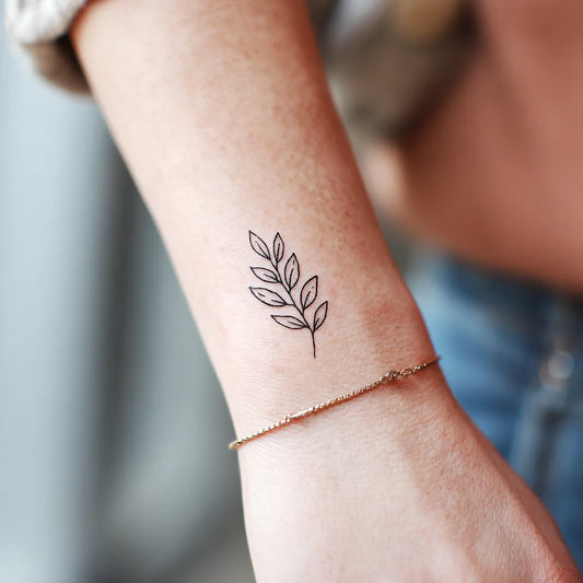 Tattoo artist working with a fine line needle configuration.