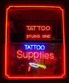 The storefront of a tattoo supply shop in Hanoi with a visible sign.