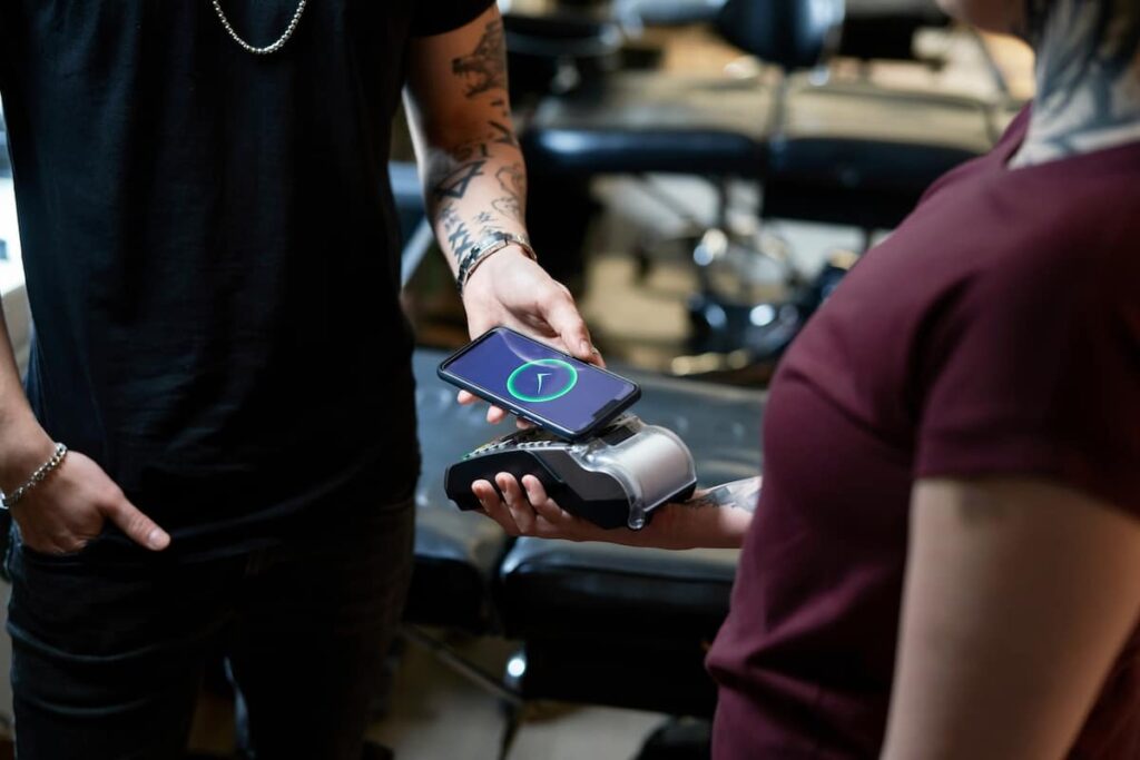 A client showing reference images on a smartphone to a tattoo artist during a walk-in consultation.