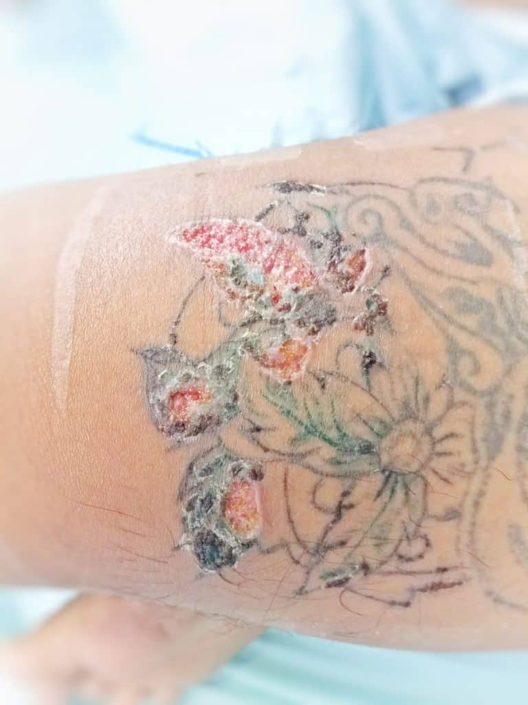 A tattoo artist working on a custom design sketch for a scheduled appointment.