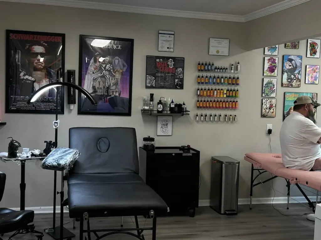 An artist places a stencil, the first step in a traditional tattoo.