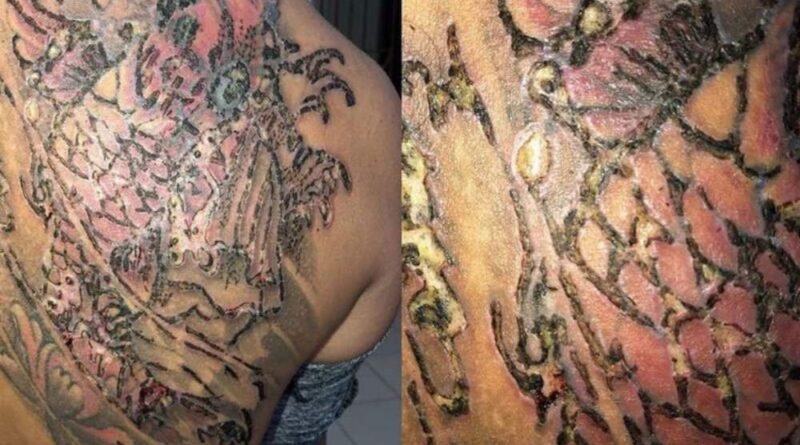 An artist reviews healed tattoo photos on a laptop, assessing long-term results.