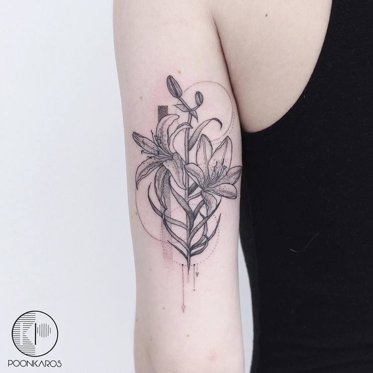 A tattoo artist sketching a black and grey design on paper during a consultation.