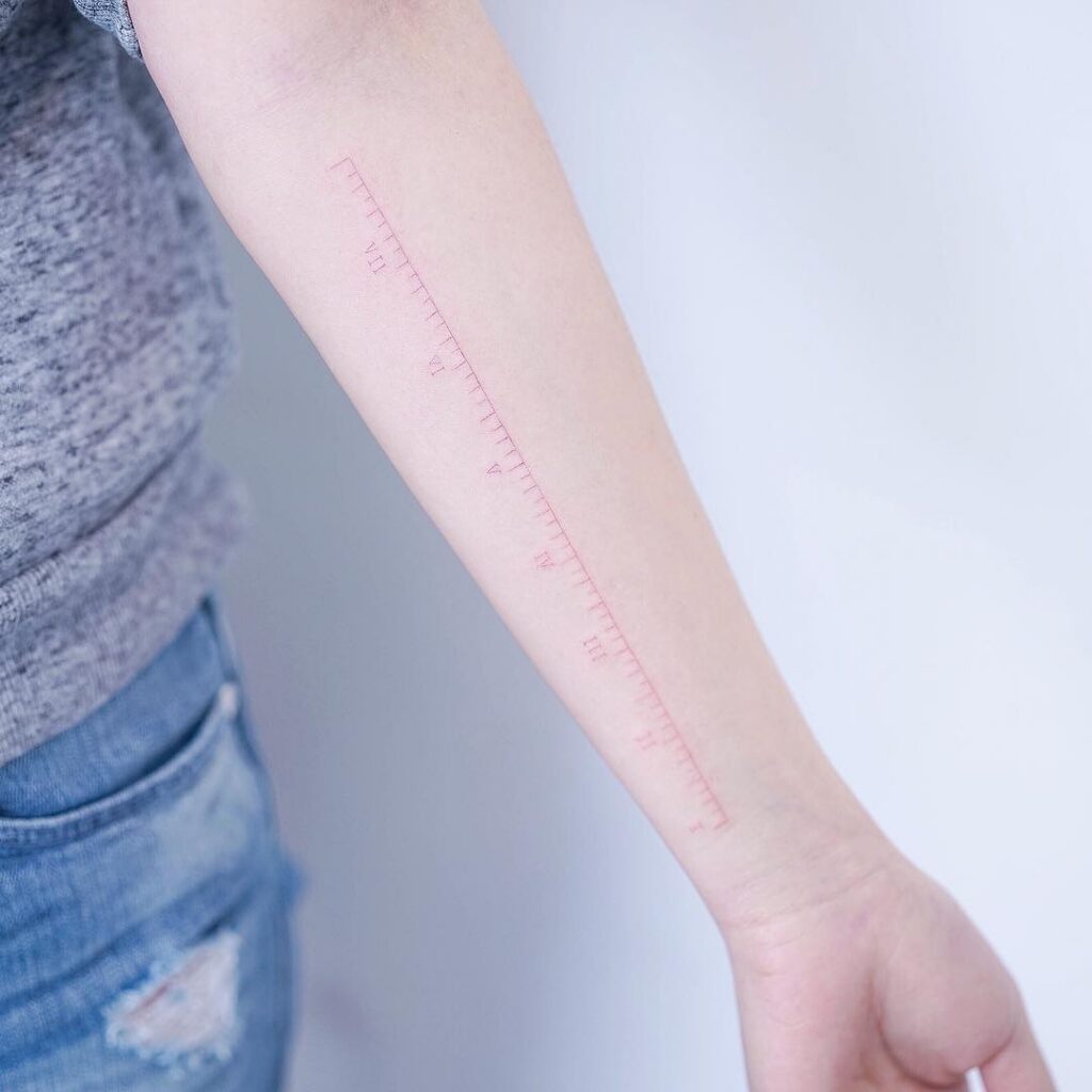 A tattoo artist applying a grey wash to create a smooth gradient on skin.