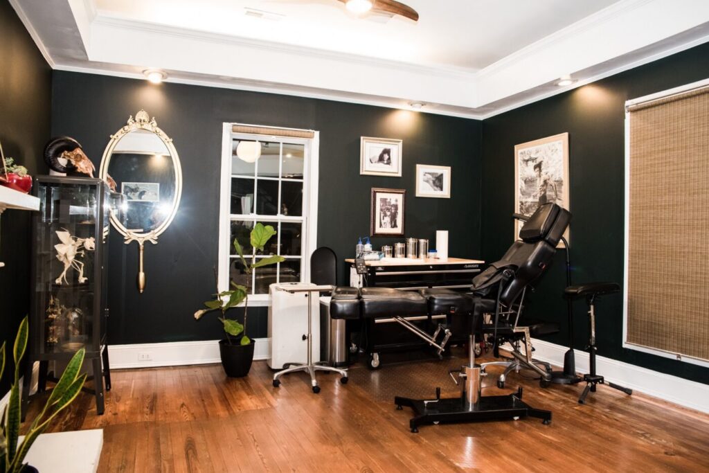 Cận cảnh máy xăm đang thực hiện mảng đen đậm của blackwork.