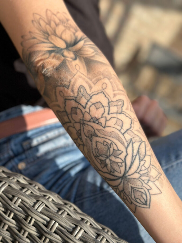 Nghệ sĩ xăm phác thảo thiết kế dotwork trên giấy có lưới chấm để lên kế hoạch phiên.