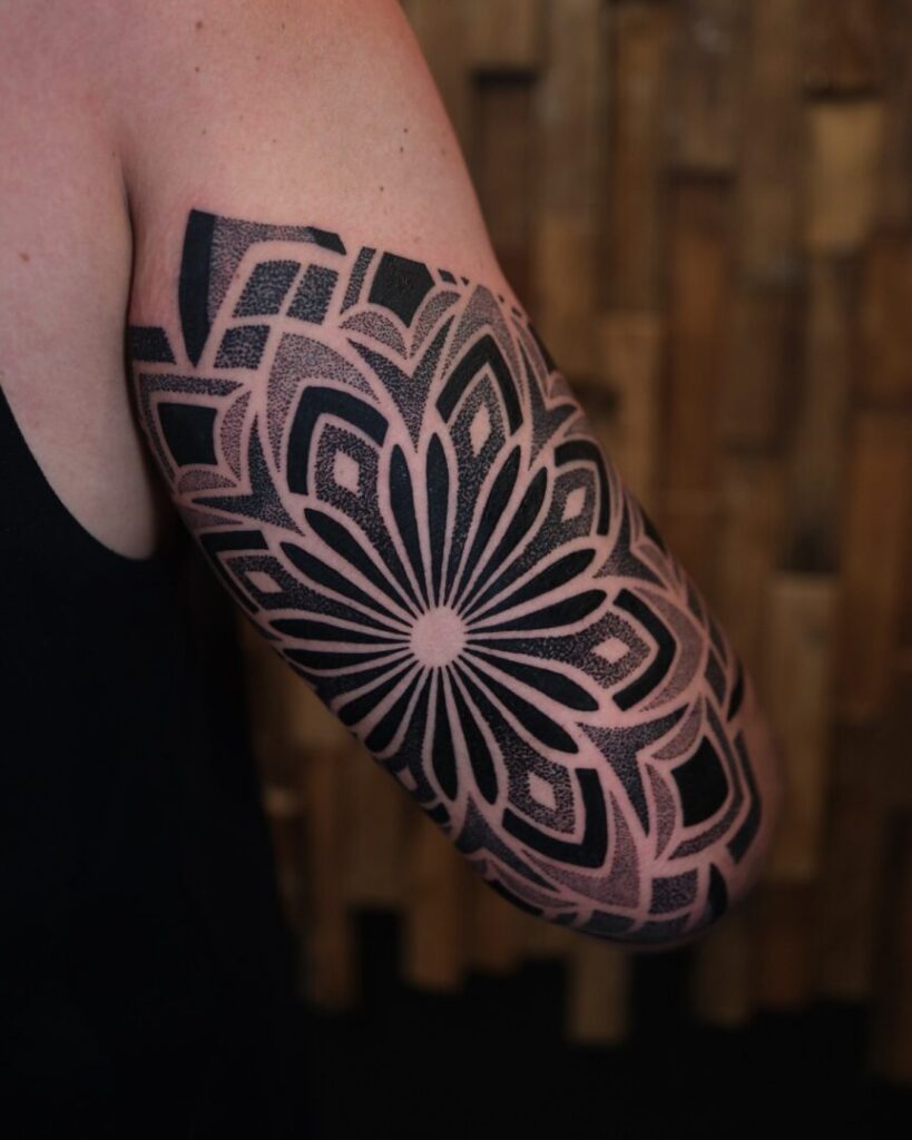 Khách hàng và nghệ sĩ xăm trao đổi về thiết kế dotwork tại bàn tư vấn.