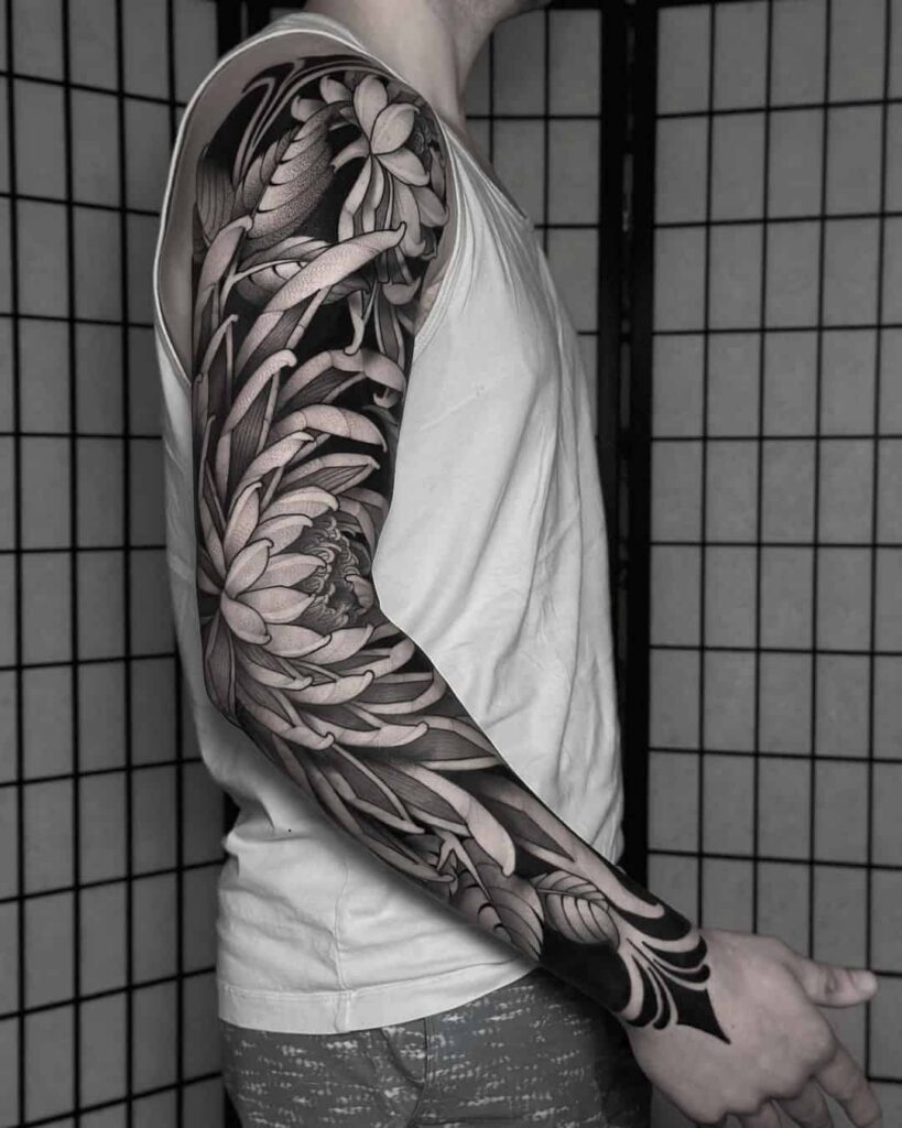 Graphic tattoo dạng sleeve với bố cục collage và tương phản rõ