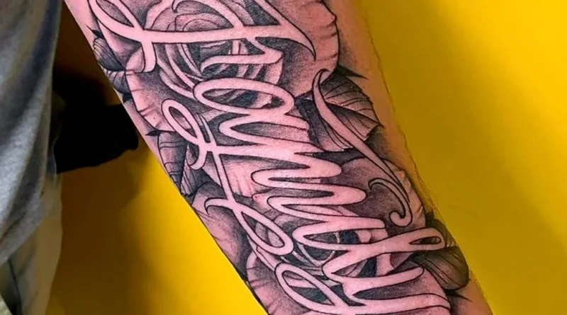 Artist sketching lettering for a tattoo design.