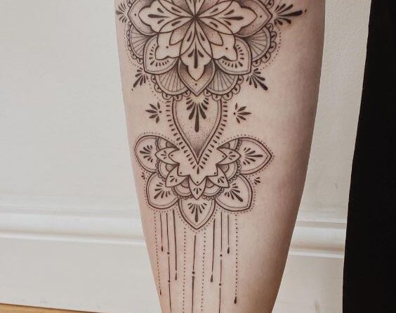 Artist sketching an ornamental tattoo design on paper