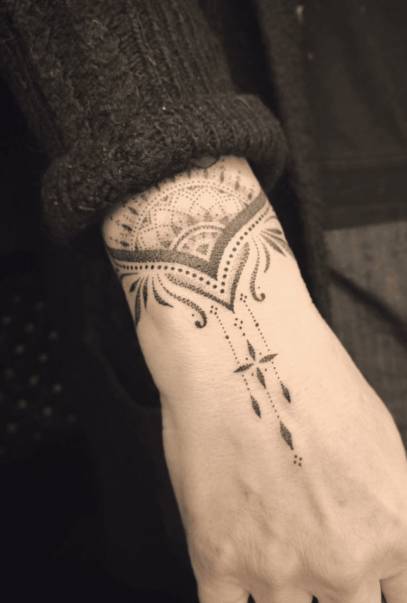Fine line ornamental tattoo on the wrist